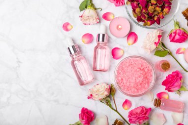 Arka planda gül yağı. Güller ve bir şişe parfümlü su. Romaterapi tedavisi. Güzellik konsepti. Spa prosedürü. Doğal organik yağ. Stres önleyici, detoks gevşetici.