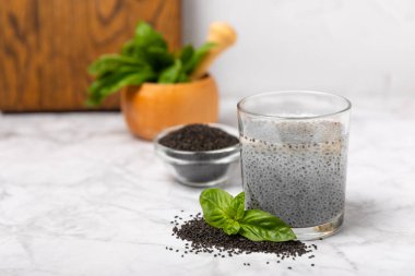 Dökümlü ahşap arka planda fesleğen tohumları. Yakın plan. Süper yemek. Ocimum bazilika. Organik fesleğen tohumu. selasih. Mesaj için yer var. Boşluğu kopyala.