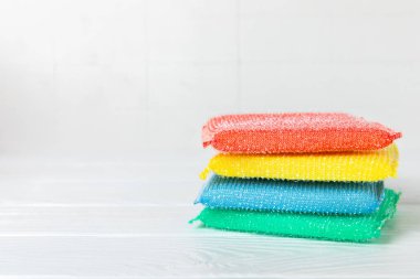 Arka planda renkli bulaşık süngerleri. Mutfak süngeri. Temizlik konsepti, temizlik hizmeti. Bulaşık deterjanı ve temiz ve kirli tabaklar. Metin için yer, kopyalama alanı. Bulaşıkları yıka..