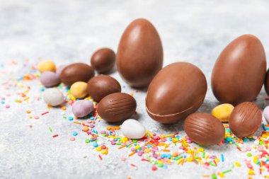 Arka planda paskalya çikolatalı yumurtası. Paskalya kutlaması. Paskalya çikolatalı tavşan. Çikolatalı tatlı yumurta. Şekerler ahşap masanın üzerinde. Mesaj için boşluk. Boşluğu kopyala. Hediye. Pankart.