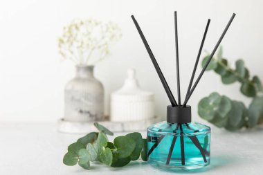 Aromatik kamış oda spreyi ahşap masa üzerinde. Doğal meyveli, çiçekli, baharatlı aromalı yayıcı. İç koku. Ev için lüks parfüm. Portakal, limon, kahve, tarçın, yıldız anason, vanilya ve orkide.