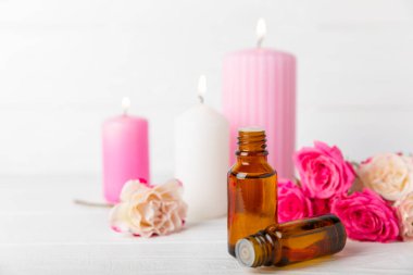 Arka planda gül yağı. Güller ve bir şişe parfümlü su. Romaterapi tedavisi. Güzellik konsepti. Spa prosedürü. Doğal organik yağ. Stres önleyici, detoks gevşetici.