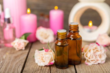 Arka planda gül yağı. Güller ve bir şişe parfümlü su. Romaterapi tedavisi. Güzellik konsepti. Spa prosedürü. Doğal organik yağ. Stres önleyici, detoks gevşetici.