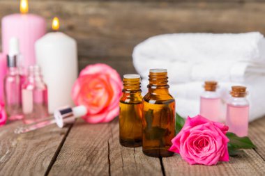 Arka planda gül yağı. Güller ve bir şişe parfümlü su. Romaterapi tedavisi. Güzellik konsepti. Spa prosedürü. Doğal organik yağ. Stres önleyici, detoks gevşetici.