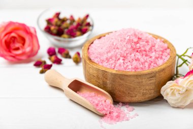 Banyo için deniz tuzu aromalı ve ahşap kaplamalı gül çiçekli. Pembe deniz tuzu. Spa tedavileri. Doğal tuz, bitkiler ve gerekli yağlar. Cilt bakımı. Mesaj için Meso. Boşluğu kopyala