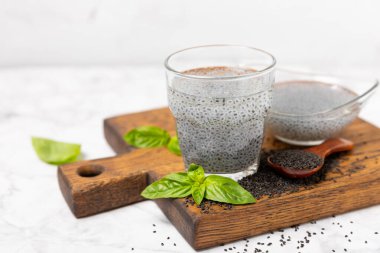 Dökümlü ahşap arka planda fesleğen tohumları. Yakın plan. Süper yemek. Ocimum bazilika. Organik fesleğen tohumu. selasih. Mesaj için yer var. Boşluğu kopyala.