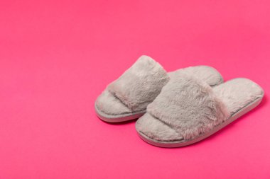 Açık renkli arka planda yumuşak terlikler, yakın plan. Ev terlikleri. Ev için rahat ayakkabılar. Ayak bakımı konsepti. Ev rahatlığı. Mesaj için yer var. Boşluğu kopyala.