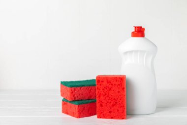 Arka planda renkli bulaşık süngerleri. Mutfak süngeri. Temizlik konsepti, temizlik hizmeti. Bulaşık deterjanı ve temiz ve kirli tabaklar. Metin için yer, kopyalama alanı. Bulaşıkları yıka..