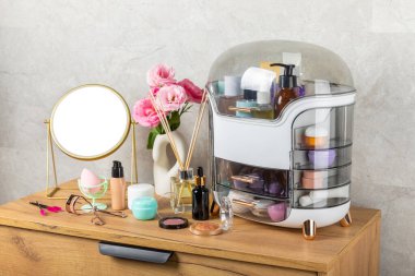Makyaj masasında kozmetik ürünleri var. Kozmetik kutusu şifoniyerde. Vücut bakımı kozmetik ürünleri. Dekoratif ve bakım ürünü. Kozmetik çanta. Depo kutusu. Güzellik konsepti. Makyaj. Metin için boşluk.