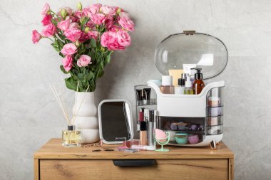 Makyaj masasında kozmetik ürünleri var. Kozmetik kutusu şifoniyerde. Vücut bakımı kozmetik ürünleri. Dekoratif ve bakım ürünü. Kozmetik çanta. Depo kutusu. Güzellik konsepti. Makyaj. Metin için boşluk.