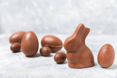 Arka planda paskalya çikolatalı yumurtası. Paskalya kutlaması. Paskalya çikolatalı tavşan. Çikolatalı tatlı yumurta. Şekerler ahşap masanın üzerinde. Mesaj için boşluk. Boşluğu kopyala. Hediye. Pankart.