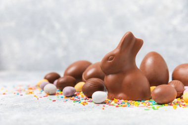 Arka planda paskalya çikolatalı yumurtası. Paskalya kutlaması. Paskalya çikolatalı tavşan. Çikolatalı tatlı yumurta. Şekerler ahşap masanın üzerinde. Mesaj için boşluk. Boşluğu kopyala. Hediye. Pankart.