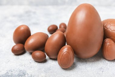 Arka planda paskalya çikolatalı yumurtası. Paskalya kutlaması. Paskalya çikolatalı tavşan. Çikolatalı tatlı yumurta. Şekerler ahşap masanın üzerinde. Mesaj için boşluk. Boşluğu kopyala. Hediye. Pankart.