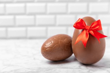 Arka planda paskalya çikolatalı yumurtası. Paskalya kutlaması. Paskalya çikolatalı tavşan. Çikolatalı tatlı yumurta. Şekerler ahşap masanın üzerinde. Mesaj için boşluk. Boşluğu kopyala. Hediye. Pankart.