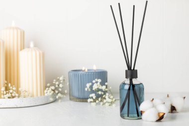Aromatik kamış oda spreyi ahşap masa üzerinde. Doğal meyveli, çiçekli, baharatlı aromalı yayıcı. İç koku. Ev için lüks parfüm. Portakal, limon, kahve, tarçın, yıldız anason, vanilya ve orkide.