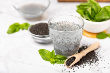 Dökümlü ahşap arka planda fesleğen tohumları. Yakın plan. Süper yemek. Ocimum bazilika. Organik fesleğen tohumu. selasih. Mesaj için yer var. Boşluğu kopyala.