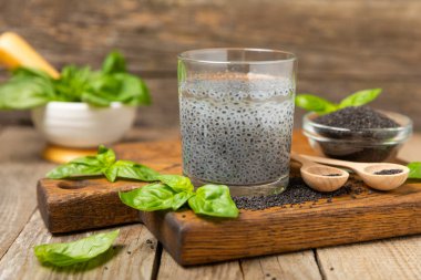 Dökümlü ahşap arka planda fesleğen tohumları. Yakın plan. Süper yemek. Ocimum bazilika. Organik fesleğen tohumu. selasih. Mesaj için yer var. Boşluğu kopyala.