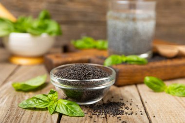 Dökümlü ahşap arka planda fesleğen tohumları. Yakın plan. Süper yemek. Ocimum bazilika. Organik fesleğen tohumu. selasih. Mesaj için yer var. Boşluğu kopyala.