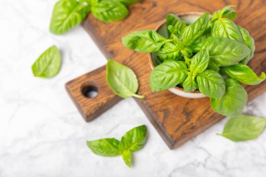 Ahşap kaplamalı yeşil fesleğen yaprakları. Mutfak otları, baharatlar. Taze yeşil organik fesleğen. Vejetaryen. Salata için yeşillik. Mesaj için yer. Boşluğu kopyala.