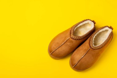 Açık renkli arka planda yumuşak terlikler, yakın plan. Ev terlikleri. Ev için rahat ayakkabılar. Ayak bakımı konsepti. Ev rahatlığı. Mesaj için yer var. Boşluğu kopyala.