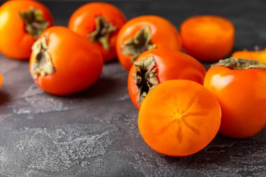 Yapay ahşap arka planda hurma. Hurma meyvesi. Bir parça olgun, sulu, tatlı hurma meyvesi. Vejetaryen. Meyve bahçesi. Yakın plan. Mesaj için yer var. Boşluğu kopyala.