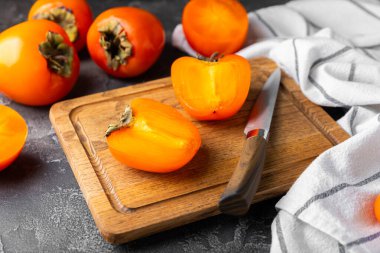 Yapay ahşap arka planda hurma. Hurma meyvesi. Bir parça olgun, sulu, tatlı hurma meyvesi. Vejetaryen. Meyve bahçesi. Yakın plan. Mesaj için yer var. Boşluğu kopyala.