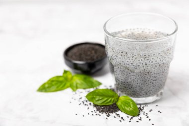 Dökümlü ahşap arka planda fesleğen tohumları. Yakın plan. Süper yemek. Ocimum bazilika. Organik fesleğen tohumu. selasih. Mesaj için yer var. Boşluğu kopyala.