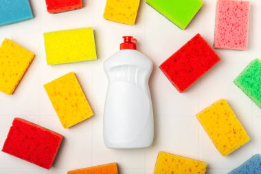 Arka planda renkli bulaşık süngerleri. Mutfak süngeri. Temizlik konsepti, temizlik hizmeti. Bulaşık deterjanı ve temiz ve kirli tabaklar. Metin için yer, kopyalama alanı. Bulaşıkları yıka..