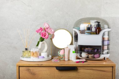 Makyaj masasında kozmetik ürünleri var. Kozmetik kutusu şifoniyerde. Vücut bakımı kozmetik ürünleri. Dekoratif ve bakım ürünü. Kozmetik çanta. Depo kutusu. Güzellik konsepti. Makyaj. Metin için boşluk.