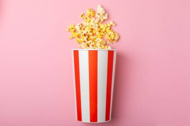 Patlamış mısır kutusu. Renkli arka planda kırmızı ve beyaz çizgili patlamış mısır kovaları. Sinema ve eğlence anlayışı. Patlamış mısırla film gecesi. Lezzetli aperatif, aperatif. Metin için yer.