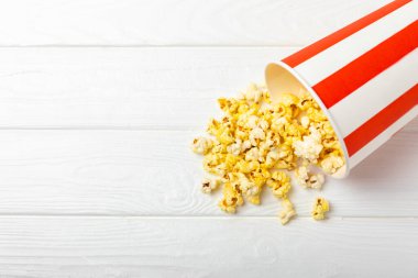 Patlamış mısır kutusu. Renkli arka planda kırmızı ve beyaz çizgili patlamış mısır kovaları. Sinema ve eğlence anlayışı. Patlamış mısırla film gecesi. Lezzetli aperatif, aperatif. Metin için yer.