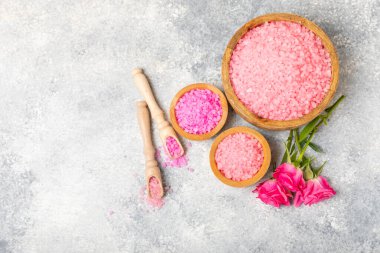 Banyo için deniz tuzu aromalı ve ahşap kaplamalı gül çiçekli. Pembe deniz tuzu. Spa tedavileri. Doğal tuz, bitkiler ve gerekli yağlar. Cilt bakımı. Mesaj için Meso. Boşluğu kopyala
