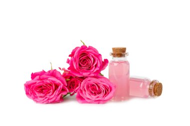 Beyaz arka planda yalıtılmış gül yağı. Güller ve bir şişe gül kokulu su. Aromaterapi tedavisi. Güzellik konsepti. Spa işlemi. Doğal organik yağ. Stres önleyici ve detoks gevşetici..