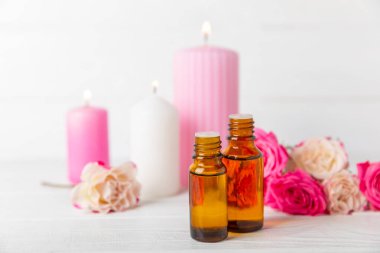 Arka planda gül yağı. Güller ve bir şişe parfümlü su. Romaterapi tedavisi. Güzellik konsepti. Spa prosedürü. Doğal organik yağ. Stres önleyici, detoks gevşetici.