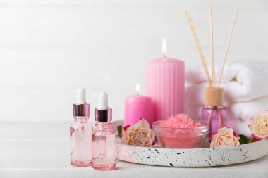 Arka planda gül yağı. Güller ve bir şişe parfümlü su. Romaterapi tedavisi. Güzellik konsepti. Spa prosedürü. Doğal organik yağ. Stres önleyici, detoks gevşetici.