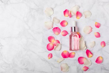 Arka planda gül yağı. Güller ve bir şişe parfümlü su. Romaterapi tedavisi. Güzellik konsepti. Spa prosedürü. Doğal organik yağ. Stres önleyici, detoks gevşetici.