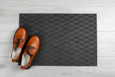 Kapı paspası. Arka planda hoş geldin paspası. Arka plandaki paspasın üzerindeki kadın ayakkabıları. Koridorda iç dekorasyon elemanı var. Yakın plan. Mesaj için yer var. Boşluğu kopyala. Koridordaki kapının yanındaki halı..