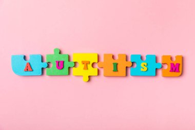 Otizm Farkındalığı Günü .2 Nisan Dünya Otizm Farkındalık Günü arka planı. Temel Tasarım Tasarımı. Renkli ahşap bulmacalar, harfler ve küplerle UTISM metni için dikkat kampanyası.