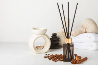Aromatik kamış oda spreyi ahşap masa üzerinde. Doğal meyveli, çiçekli, baharatlı aromalı yayıcı. İç koku. Ev için lüks parfüm. Portakal, limon, kahve, tarçın, yıldız anason, vanilya ve orkide.