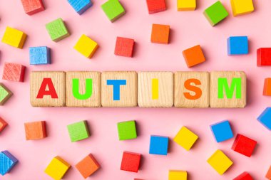 Otizm Farkındalığı Günü .2 Nisan Dünya Otizm Farkındalık Günü arka planı. Temel Tasarım Tasarımı. Renkli ahşap bulmacalar, harfler ve küplerle UTISM metni için dikkat kampanyası.