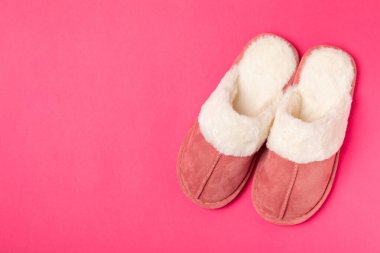 Açık renkli arka planda yumuşak terlikler, yakın plan. Ev terlikleri. Ev için rahat ayakkabılar. Ayak bakımı konsepti. Ev rahatlığı. Mesaj için yer var. Boşluğu kopyala.