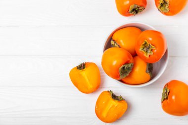 Yapay ahşap arka planda hurma. Hurma meyvesi. Bir parça olgun, sulu, tatlı hurma meyvesi. Vejetaryen. Meyve bahçesi. Yakın plan. Mesaj için yer var. Boşluğu kopyala.