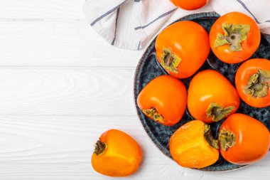 Yapay ahşap arka planda hurma. Hurma meyvesi. Bir parça olgun, sulu, tatlı hurma meyvesi. Vejetaryen. Meyve bahçesi. Yakın plan. Mesaj için yer var. Boşluğu kopyala.