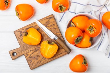 Yapay ahşap arka planda hurma. Hurma meyvesi. Bir parça olgun, sulu, tatlı hurma meyvesi. Vejetaryen. Meyve bahçesi. Yakın plan. Mesaj için yer var. Boşluğu kopyala.