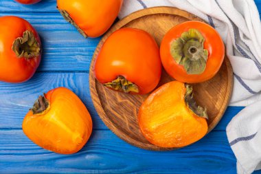 Yapay ahşap arka planda hurma. Hurma meyvesi. Bir parça olgun, sulu, tatlı hurma meyvesi. Vejetaryen. Meyve bahçesi. Yakın plan. Mesaj için yer var. Boşluğu kopyala.