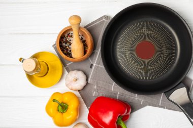 Kızartma tavası. Boş kızartma tavası ve mutfak aletleri ahşap dokulu arka planda. Yemek konsepti. Üst Manzara. Mesaj için yer var. Düz yatıyordu. Tarif.