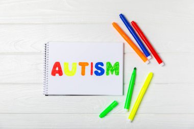 Otizm Farkındalığı Günü .2 Nisan Dünya Otizm Farkındalık Günü arka planı. Temel Tasarım Tasarımı. Renkli ahşap bulmacalar, harfler ve küplerle UTISM metni için dikkat kampanyası.