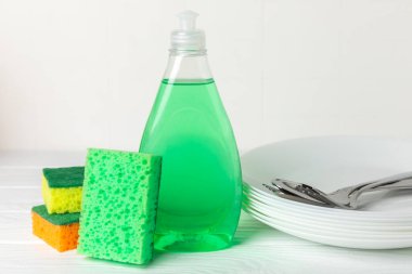 Arka planda renkli bulaşık süngerleri. Mutfak süngeri. Temizlik konsepti, temizlik hizmeti. Bulaşık deterjanı ve temiz ve kirli tabaklar. Metin için yer, kopyalama alanı. Bulaşıkları yıka..