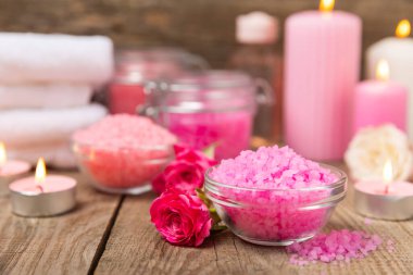 Banyo için deniz tuzu aromalı ve ahşap kaplamalı gül çiçekli. Pembe deniz tuzu. Spa tedavileri. Doğal tuz, bitkiler ve gerekli yağlar. Cilt bakımı. Mesaj için Meso. Boşluğu kopyala