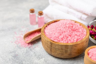 Banyo için deniz tuzu aromalı ve ahşap kaplamalı gül çiçekli. Pembe deniz tuzu. Spa tedavileri. Doğal tuz, bitkiler ve gerekli yağlar. Cilt bakımı. Mesaj için Meso. Boşluğu kopyala